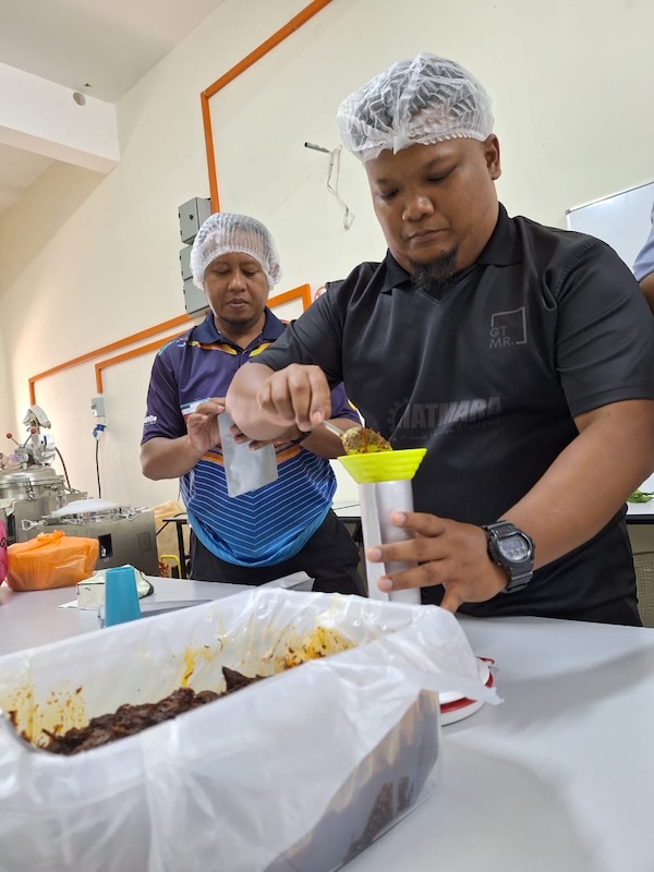 peserta kursus retort di RetortLab Bangi sedang mengisi pouch makanan 